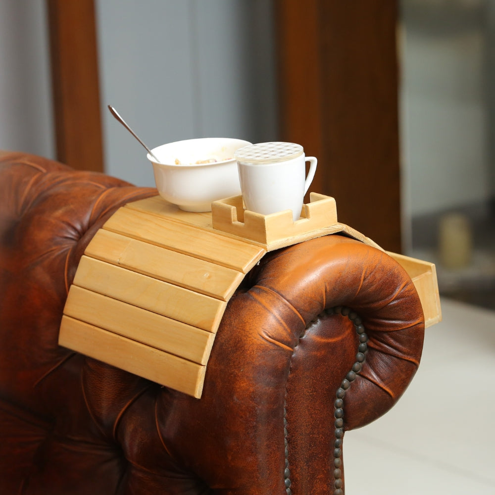 Wooden tray with a cup and bowl on a brown leather armchair
