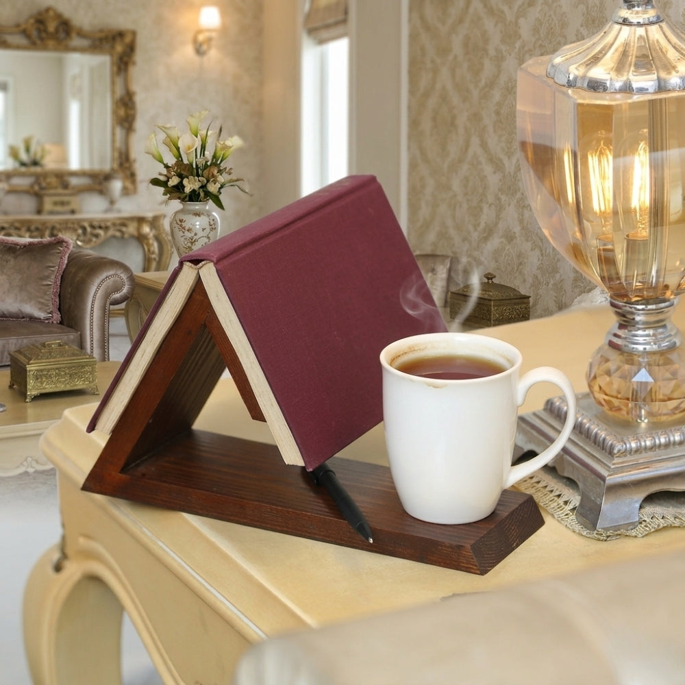 Book stand holding a book next to a cup of tea on a table in a cozy room.